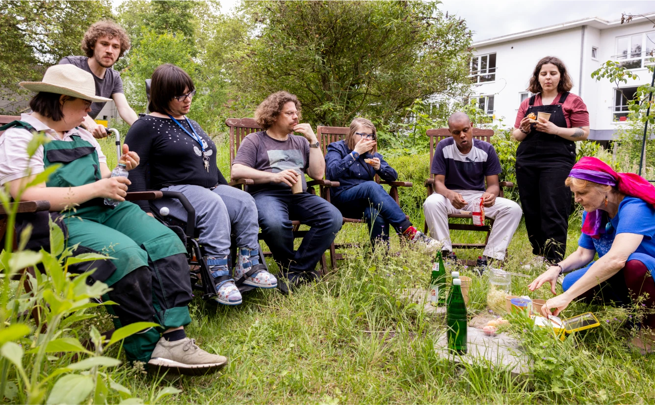 erwachsene_freizeit_gaertnern Eine Personengruppe sitzt im Garten.